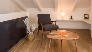 A modern living room with a dark-colored sofa, a wooden coffee table, and a decorative cactus plant. - Le Niche Holiday Home - Terrace by Wonderful Italy (Palermo)