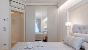 Una habitación de hotel con una cama, una mesita de noche con dos tazas, una lámpara y un espejo.