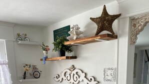 A kitchen with white cabinetry, a wooden countertop, a coffee bar, decorative items, and a star ornament on the wall. - Charming Beach Cottage,  Newly renovated. located in Ocean City Nj. (Ocean City)