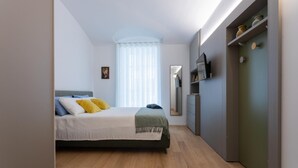 A modern bedroom with a bed, bedside table, and a wardrobe.