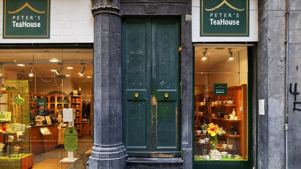 A storefront with a green door and signage for "Peter's TeaHouse."