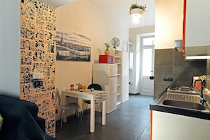A compact kitchen with a dining area, a refrigerator, a microwave, and a stove.
