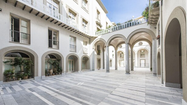 A spacious courtyard with a tiled floor, multiple arches, and columns. - Luxury Gattopardo Loft - Lago Design by Wonderful Italy (Palermo)
