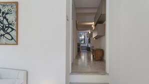 A hallway with a staircase leading to a kitchen area.