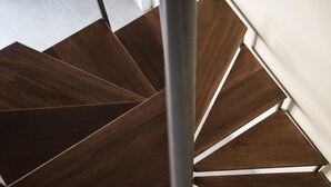 A spiral staircase with wooden steps and metal railings.