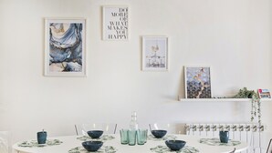 Un espace repas comprenant une table ronde, des chaises transparentes et des bols décoratifs.