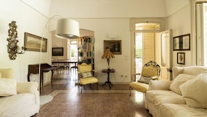 A spacious living room with a fireplace, a dining area, and a library. - Villa Manfredi con Piscina by Wonderful Italy (Fasano)