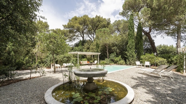 A garden with a circular pond, a pergola, and lounge chairs. - Villa Manfredi con Piscina by Wonderful Italy (Fasano)