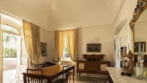 A dining room with a wooden table and chairs, a cabinet with decorative items, and a large mirror. - Villa Manfredi con Piscina by Wonderful Italy (Fasano)
