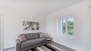 A modern living room with a grey sofa, a striped rug, and a painting on the wall. - San Carlo Borromeo 2 by Wonderful Italy (Soiano del Lago)