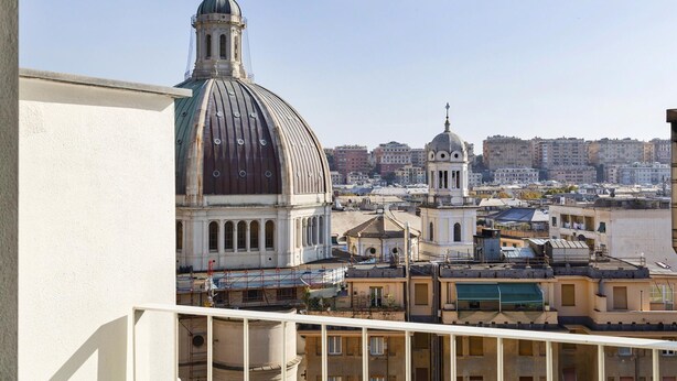 A cityscape with a prominent dome structure and a smaller building with a dome, surrounded by residential buildings. - Deluxe Apartment - Avio by Wonderful Italy (Genoa)