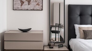 A modern bedroom with a bed, a dresser, a mirror, and a world map artwork. - Studio Grey al Parco Montagnola by Wonderful Italy (Bologna)