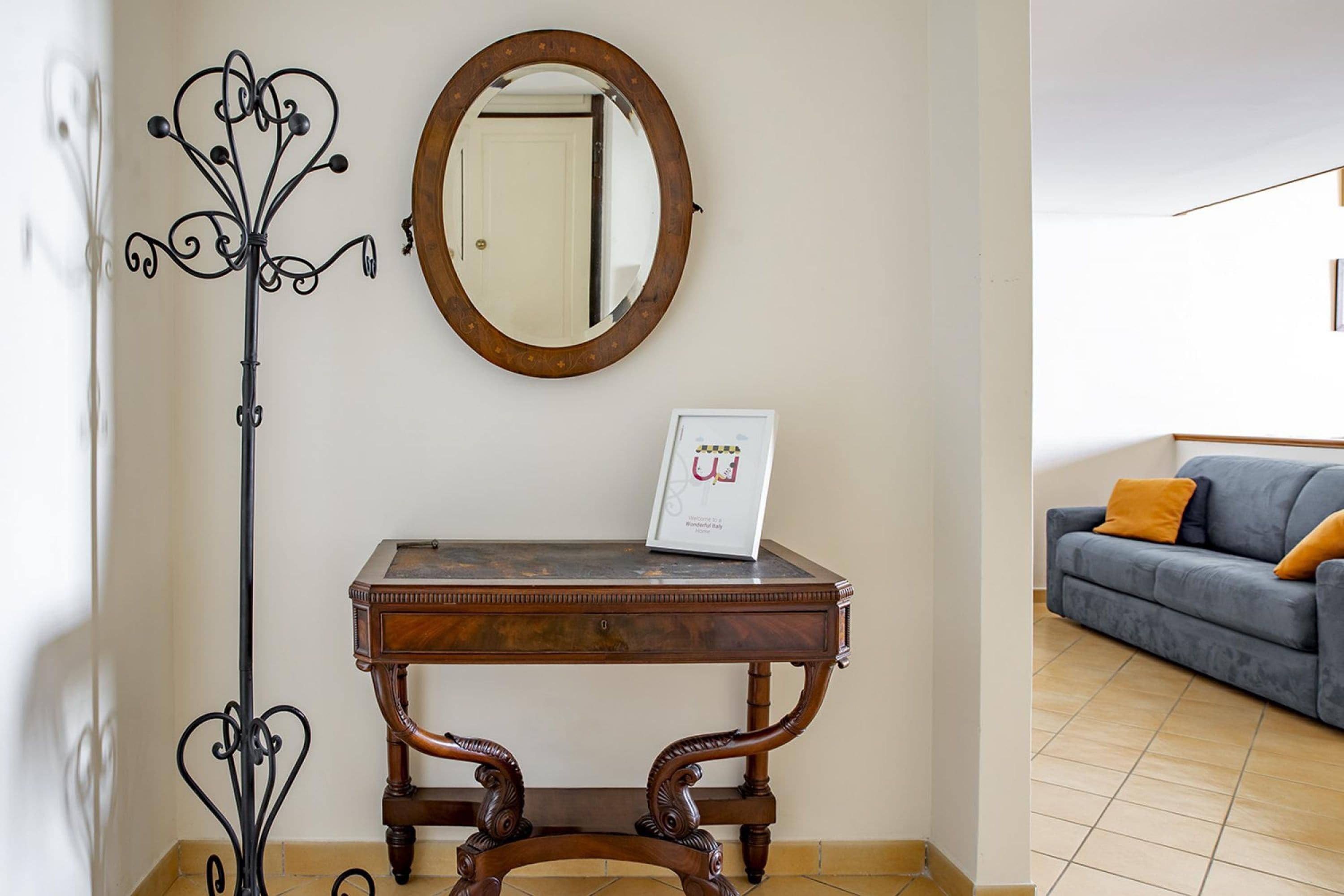 Une pièce avec une table en bois, un miroir et un panneau encadré.