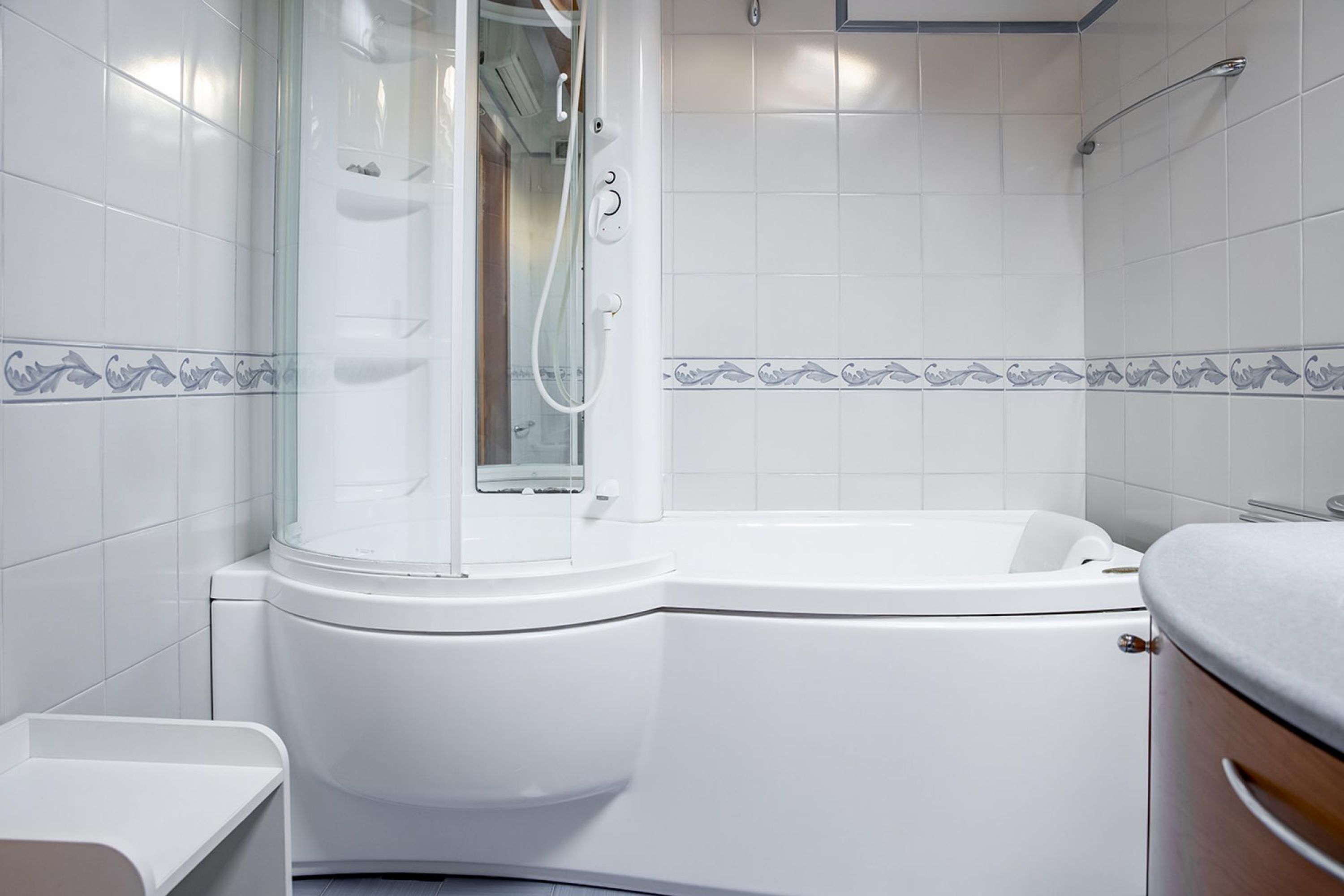 Et moderne badeværelse med et hjørnebadekar, et badekar og et toilet.