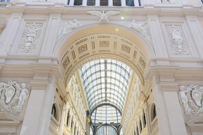 A grand architectural structure with ornate carvings and a glass ceiling.