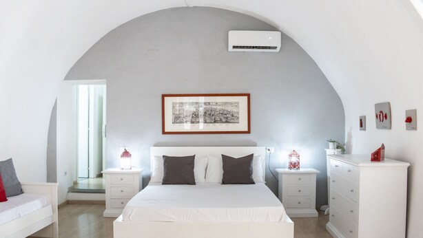 A modern bedroom with a large bed, white nightstands, a dresser, and a framed picture above the bed. - O Panaro ai Quartieri Spagnoli (Naples)