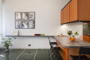 A modern kitchen with a granite countertop, wooden cabinets, and a dining area with a bench.