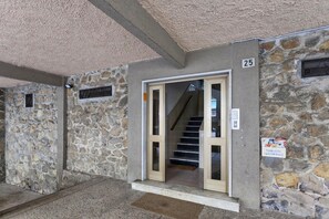 A stone building with a numbered door, a staircase, and a sign indicating a public condominium. - La Casa di Lorenzo by Wonderful Italy (Genoa)