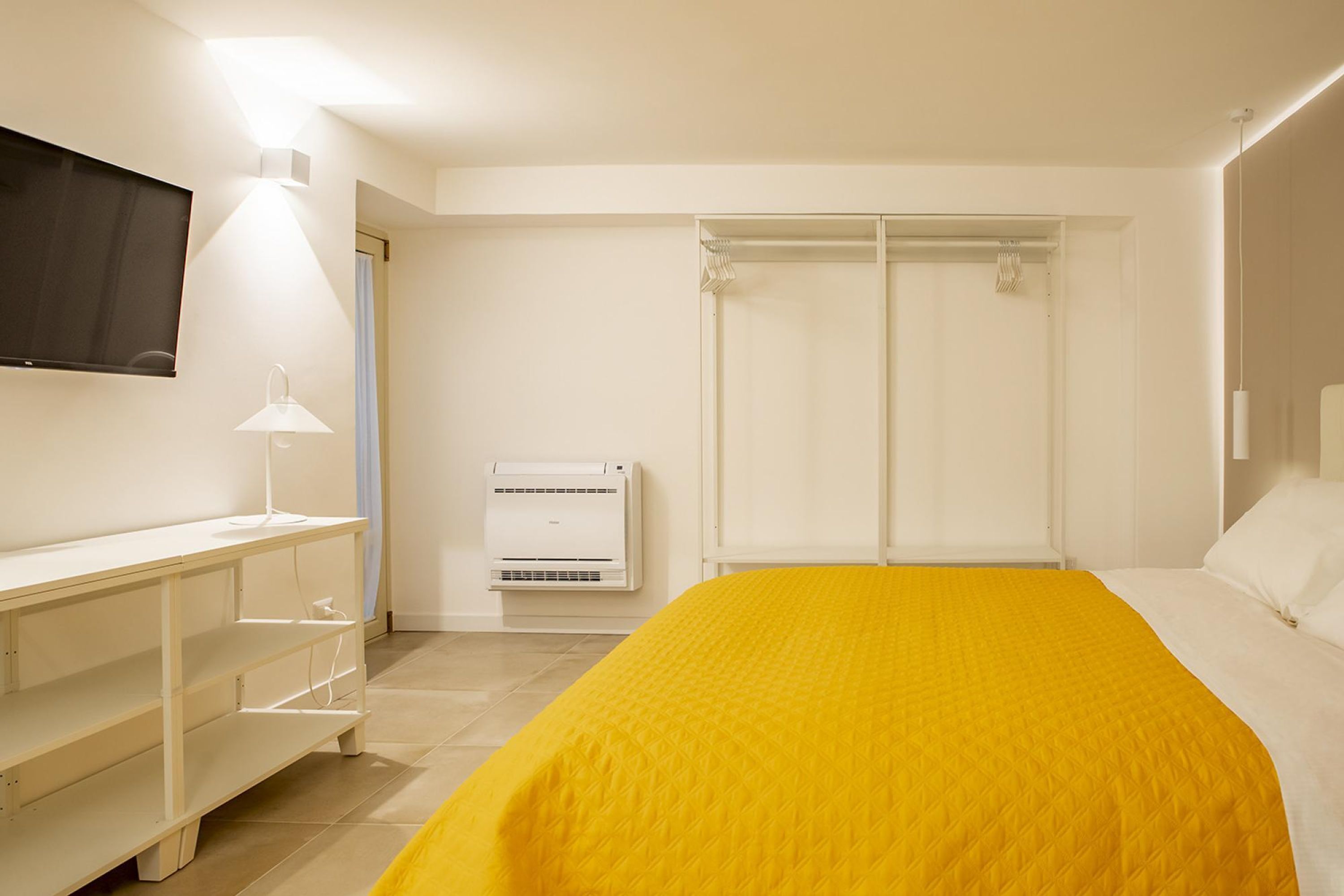 Une chambre à coucher comprenant un lit, un bureau, une chaise, une télévision et une armoire.