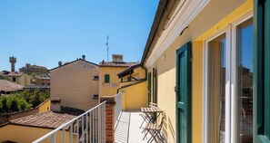 A balcony with a tiled floor, a table, and chairs. - Appartamento all Orto Botanico by Wonderful Italy (Bologna)
