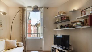 A compact living space with a sofa, a TV, and bookshelves. - Nel Cuore del Borgo di Camogli by Wonderful Italy (Camogli)