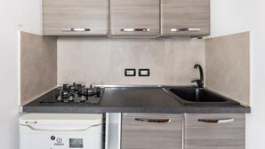 A modern kitchen with grey cabinetry, a stainless steel sink, and a built-in dishwasher. - Studio Malcontenti con Terrazzo by Wonderful Italy (Bologna)