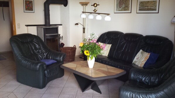 A living room with two black leather sofas, a coffee table, and a fireplace.