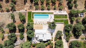 An aerial view of a modern house with a swimming pool, surrounded by trees and a well-maintained lawn. - Villa Degli Ulivi con Piscina by Wonderful Italy (Ostuni)