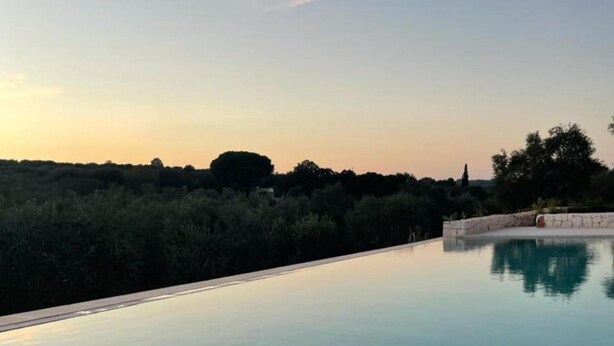 A serene infinity pool with a clear view of the surrounding landscape during sunset. - Villa Degli Ulivi con Piscina by Wonderful Italy (Ostuni)