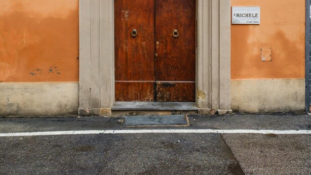A building with a wooden door, a balcony with metal railings, and a sign indicating 'Piazza San Michele'. - San Michele Apts by Wonderful Italy - Aluminium (Bologna)