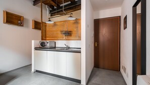 A modern kitchen with white cabinets, a wooden countertop, and a built-in microwave. - San Michele Apts by Wonderful Italy - Aluminium (Bologna)