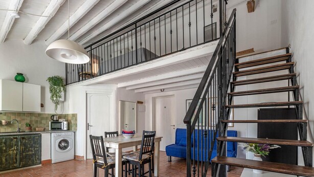 Eine mehrstöckige Wohnung mit Küche, Essbereich und Treppe.