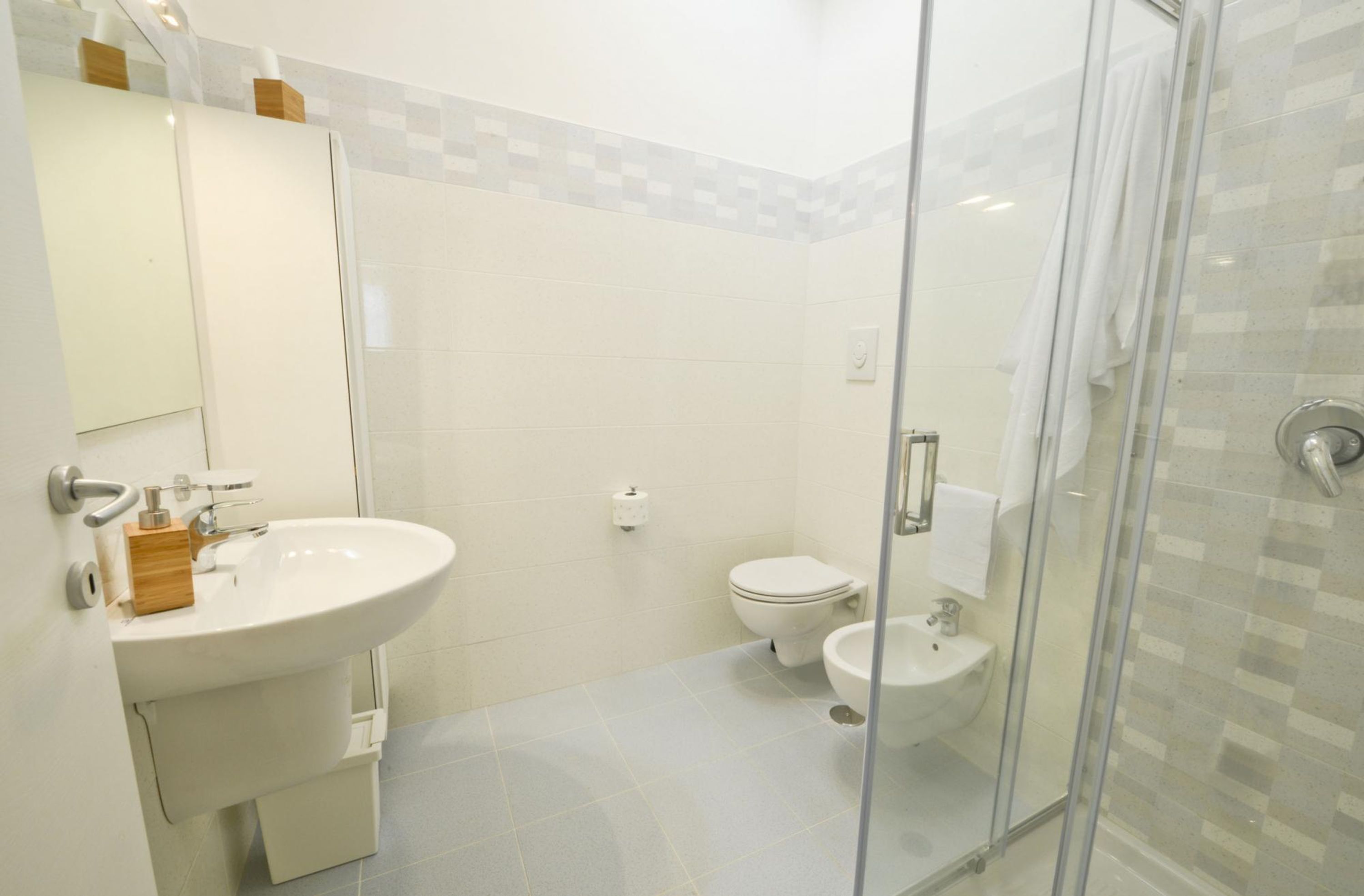 Une salle de bain moderne avec une douche à parois de verre, un lavabo blanc et des toilettes.