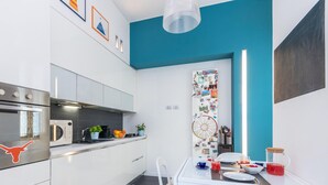 Eine moderne Küche mit weißen Schränken, einem Edelstahlbackofen und einer blauen Akzentwand.