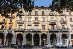 Un immeuble à plusieurs étages de style architectural classique, caractérisé par des portes en arc de cercle et des balcons.