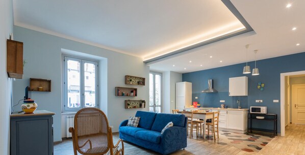 Un appartement moderne comprenant un salon, une cuisine et un coin repas.