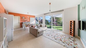 Een moderne woonkamer met een bank, een eettafel en een keukenhoek.
