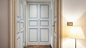 A hallway with double doors, a floor lamp, and a radiator. - Santa Chiara Apartment by Wonderful Italy (Genoa)