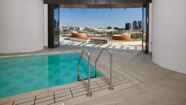 Una piscina en la azotea con vistas despejadas al horizonte de la ciudad.