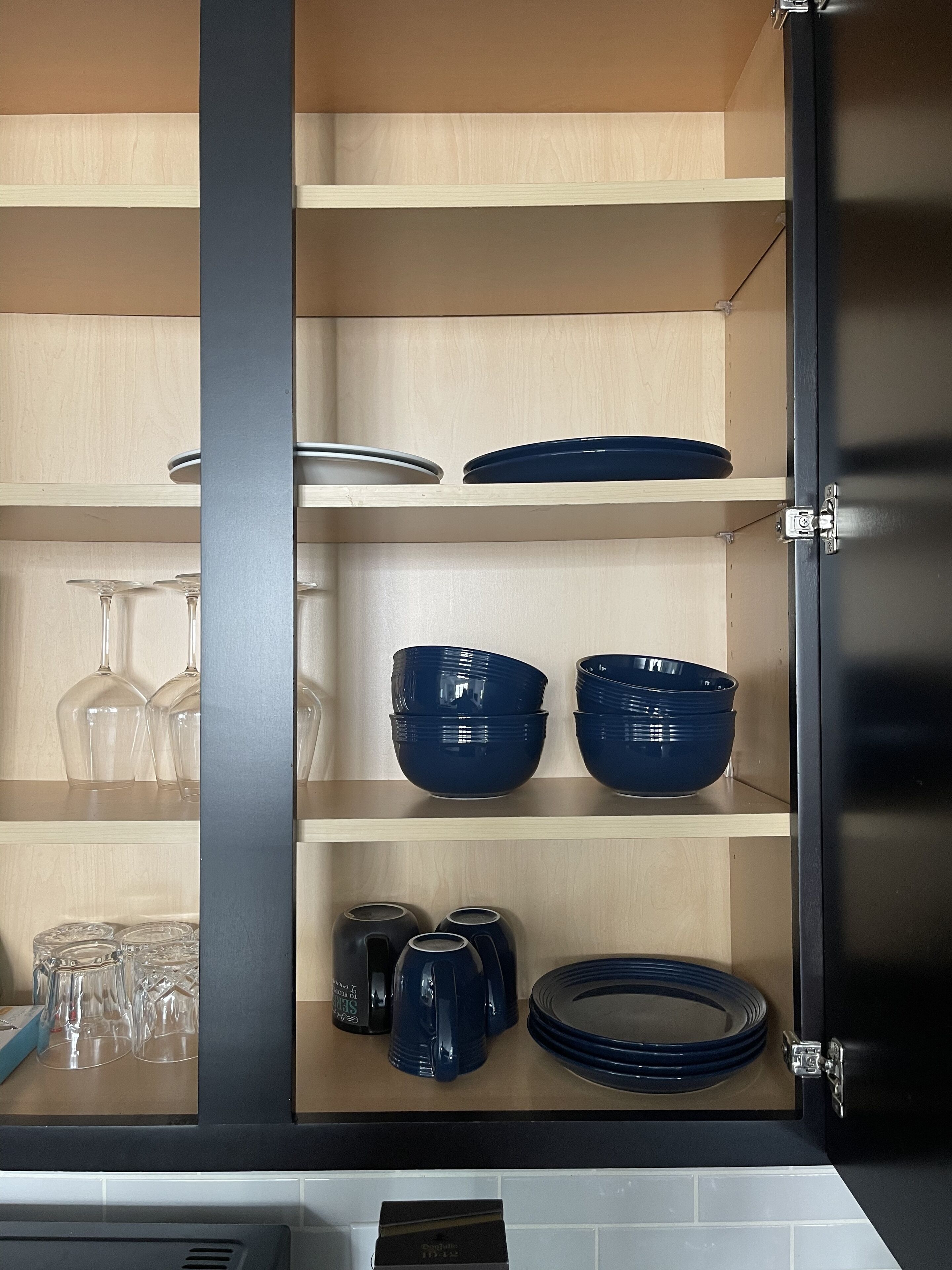 Ein Küchenschrank mit Regalen voller Küchenutensilien.