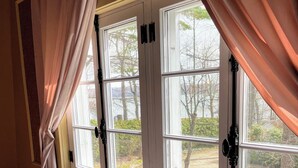 Ein Zimmer mit Heizkörper, Fenster mit weißen Rahmen und Vorhängen.