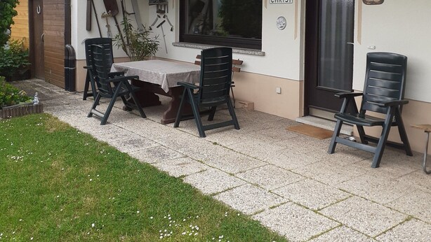A patio with a table and chairs, a window, and a door labeled "CHRISTI".