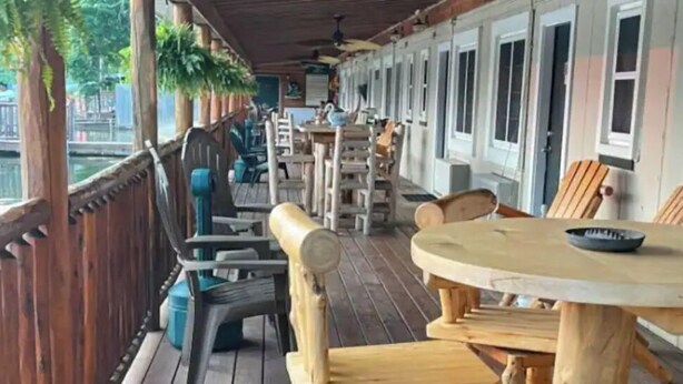 Une terrasse en bois avec des sièges extérieurs et une vue sur une rivière.