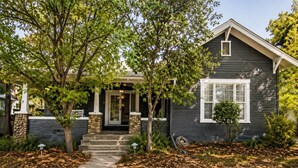 A two-story house with a front porch, stone pillars, and a small tree in the yard. - Historic Valier Lodge near Lake Francis (Valier)