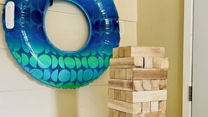 Un flotador azul en forma de aros y una torre de bloques de madera junto a una pared.
