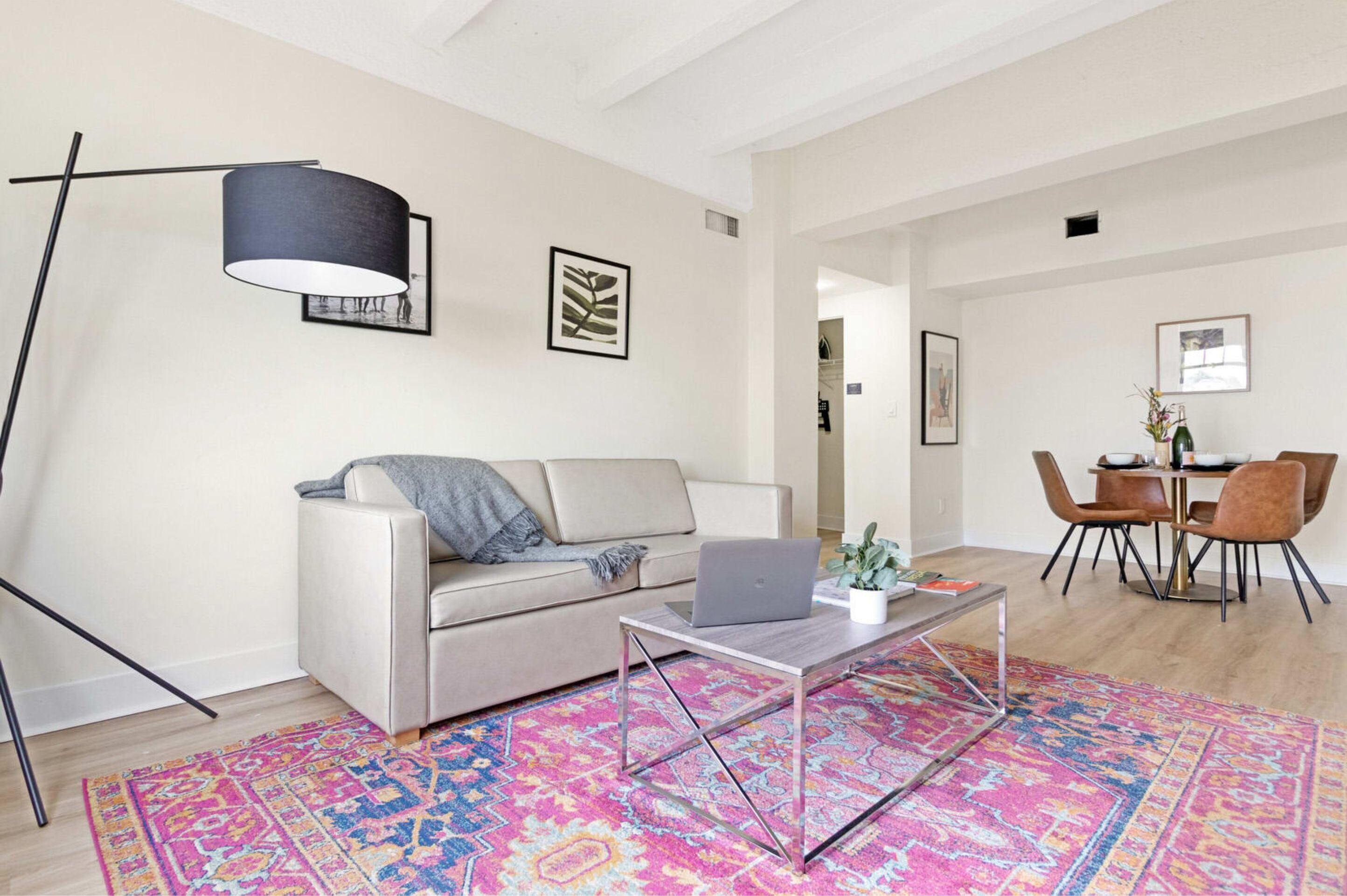 Un salon moderne avec un canapé, une table basse et un coin repas avec des chaises.