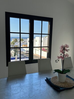 A room with a large window, a table, chairs, and a potted orchid. - Fabulous Detached Luxury Villa! Beach 5 min, h/pool,Sky TV, BBQ,Private terrace (Tías)