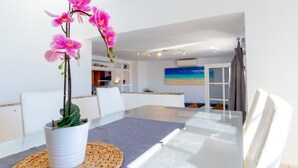 A dining area with a table, chairs, a woven placemat, and a potted orchid. - Fabulous Detached Luxury Villa! Beach 5 min, h/pool,Sky TV, BBQ,Private terrace (Tías)