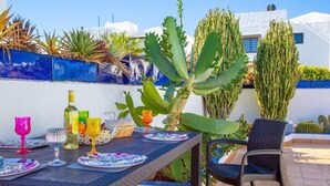 An outdoor dining area with a table set for two, surrounded by various cacti and succulents. - Fabulous Detached Luxury Villa! Beach 5 min, h/pool,Sky TV, BBQ,Private terrace (Tías)