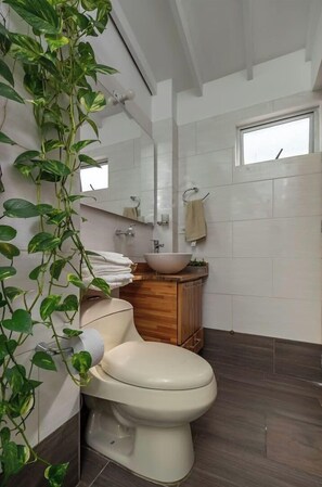 Un baño moderno con inodoro, lavabo y espejo.